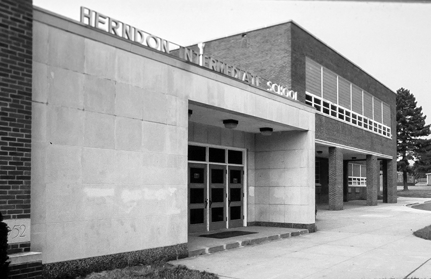 Black and white photograph of the main entrance of Herndon Intermediate School.